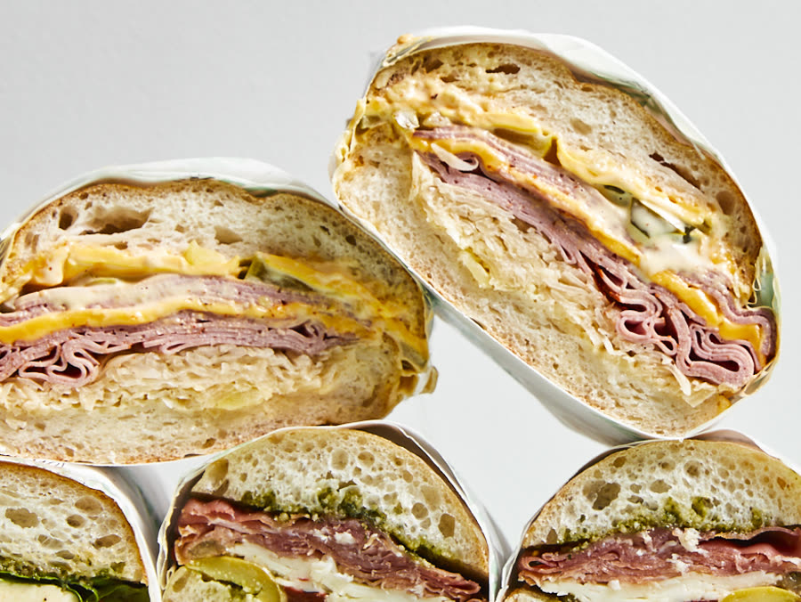 Close crop of Matteo's own photograph — wrapped panini halves stacked.